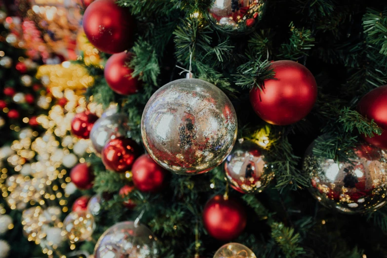 christmas balls and tinsel on top of a tree