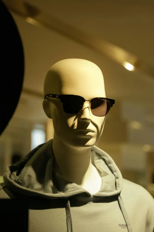 a male mannequin wearing glasses and a hood