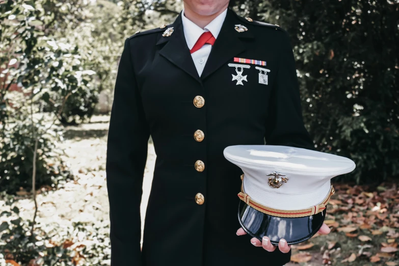 a man in uniform holding a white plate with red ribbon