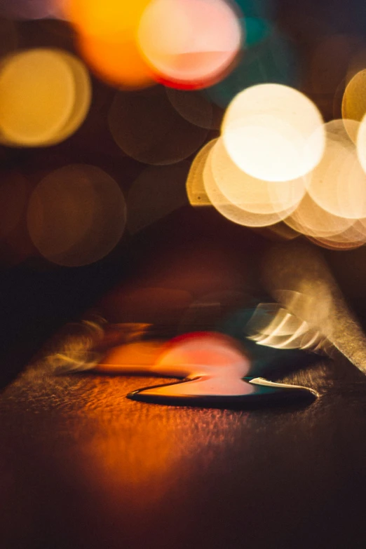 a phone sitting on top of a table covered in blurred lights