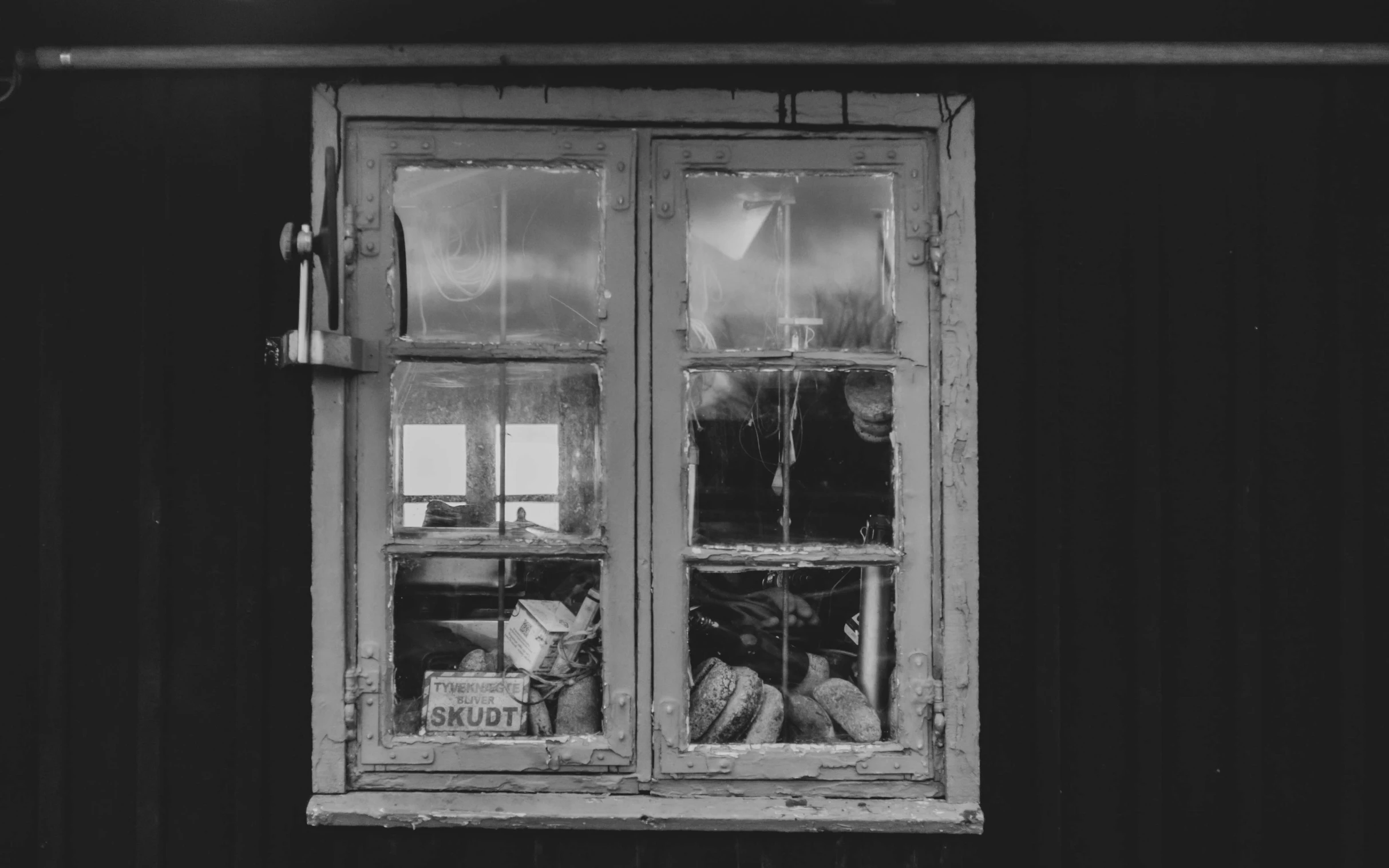 a black and white po shows the inside of a window with glass panes, two baskets and bread on it