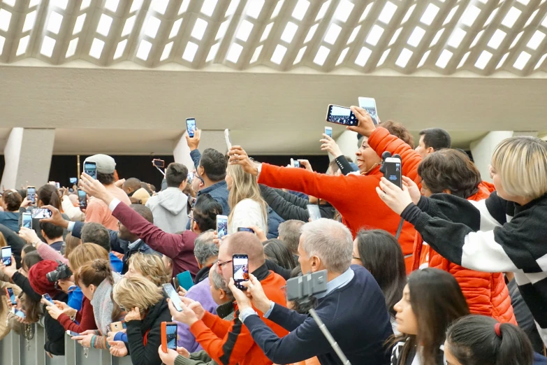 people standing in front of each other taking pictures