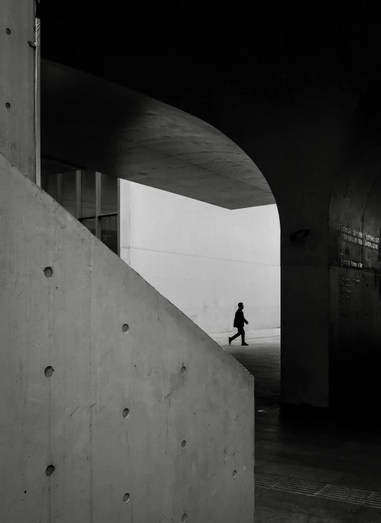 a woman walks underneath the underside of a bridge