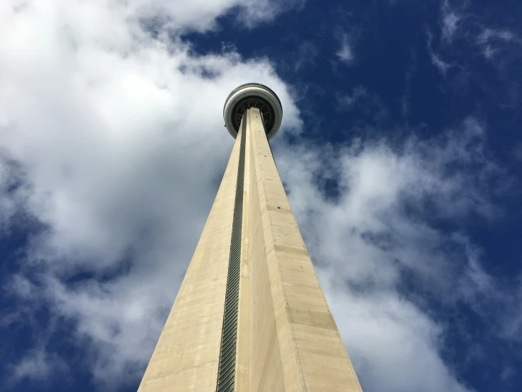 a large tall building towering above a blue cloudy sky