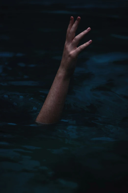 a person's arm floating in water with it's hand raised up