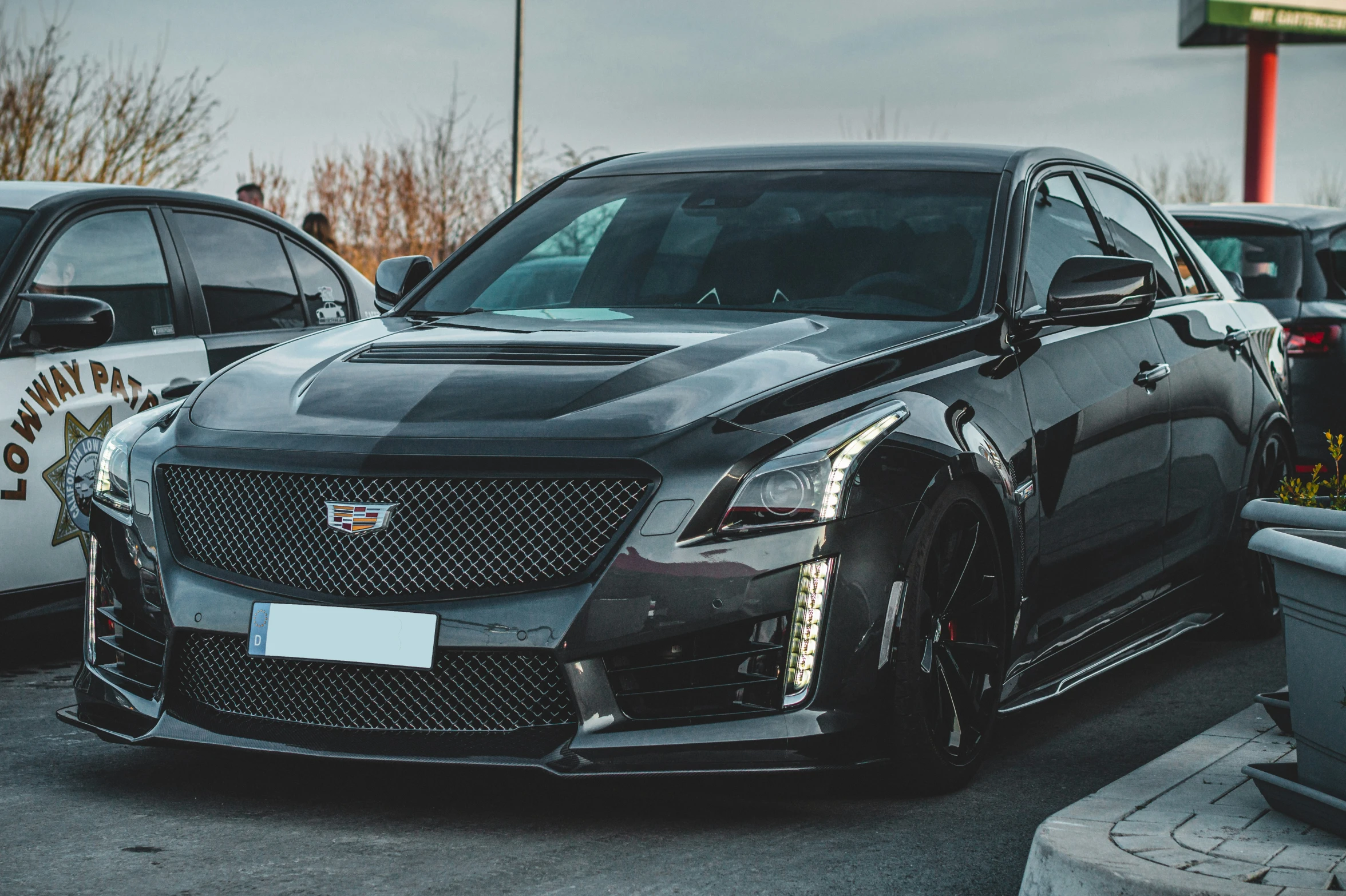 a close up view of a black car near several other cars