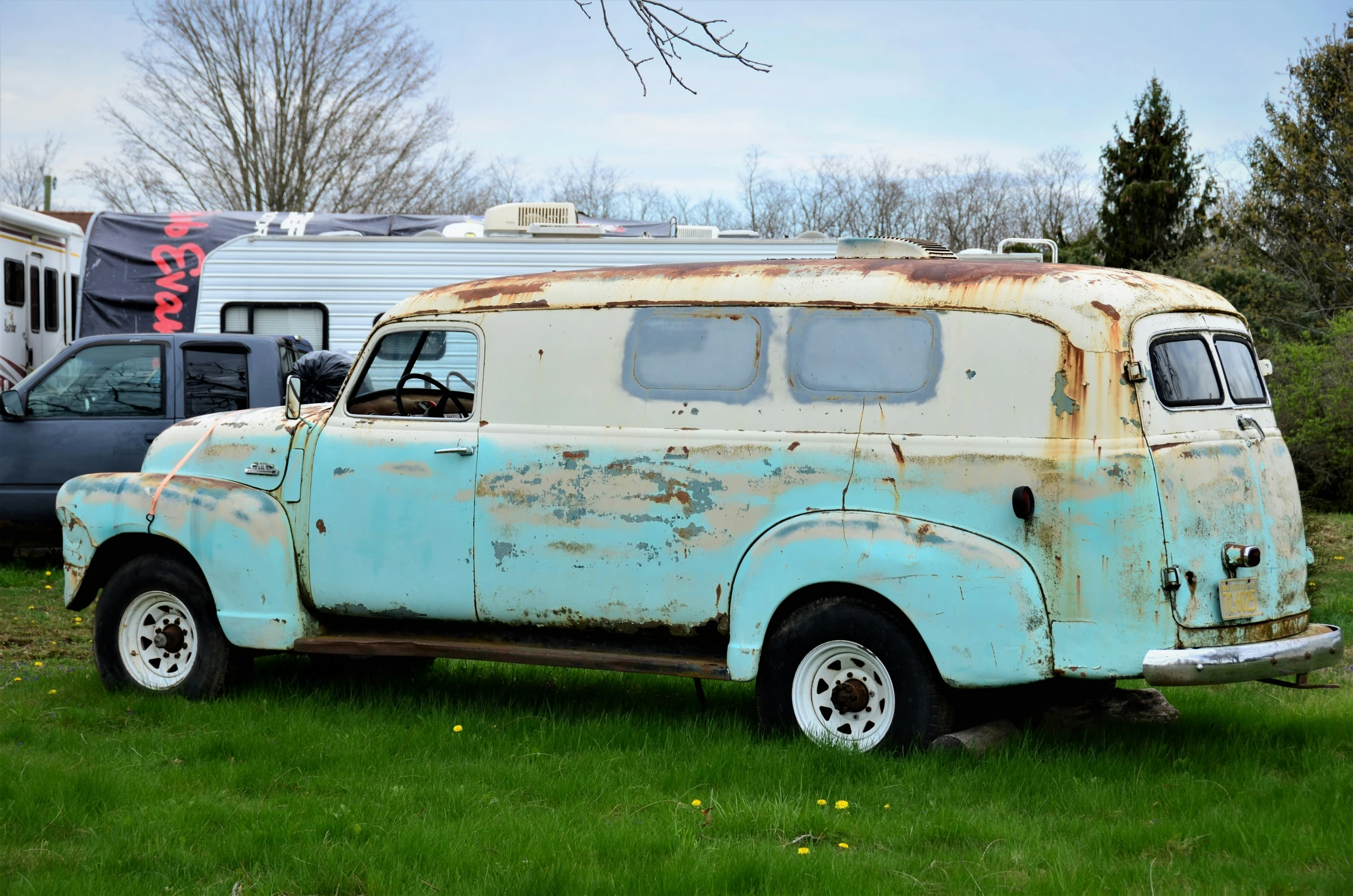 an old rusty and white van in grass
