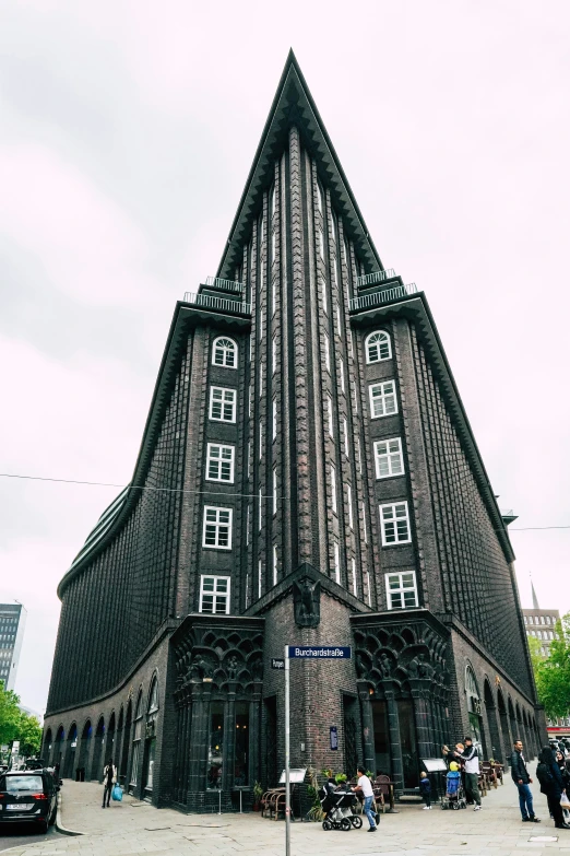 a very tall, unique house with windows and large door openings