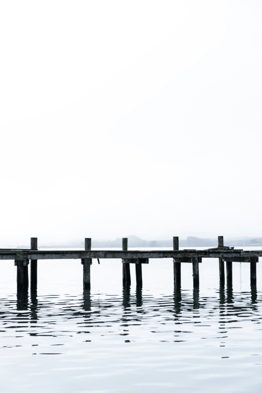 a pier with one person standing on it in the water