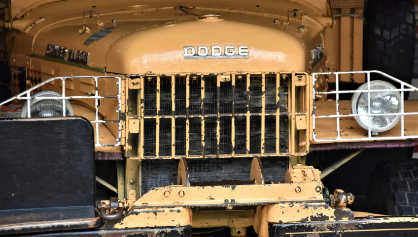 a close up of the front end of an old yellow truck