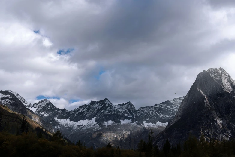 a majestic mountain range beneath a cloudy blue sky