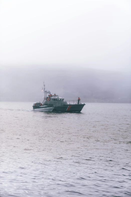 a boat sailing out towards the shore in a foggy day