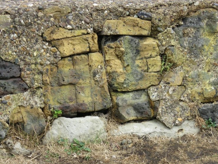 a rock wall is covered with moss and rocks