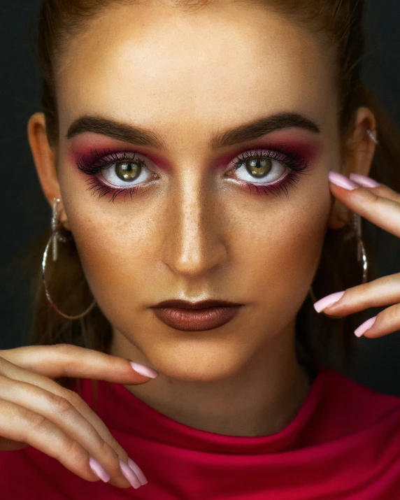 close up portrait of woman with red makeup and large hoop earrings