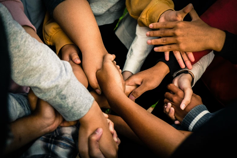 a lot of hands holding up and touching each other