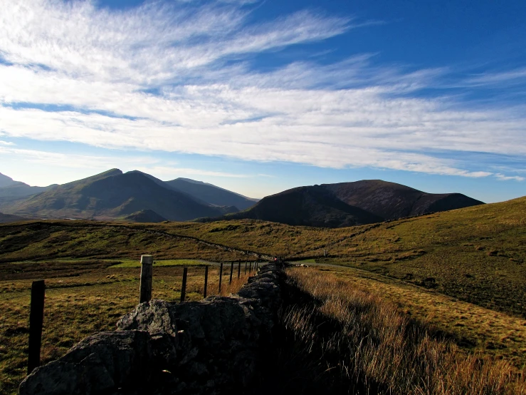 an old fashioned farm fence and hill in the country