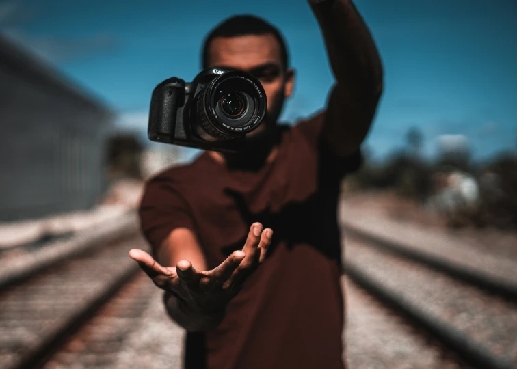 a man is holding a camera over his head