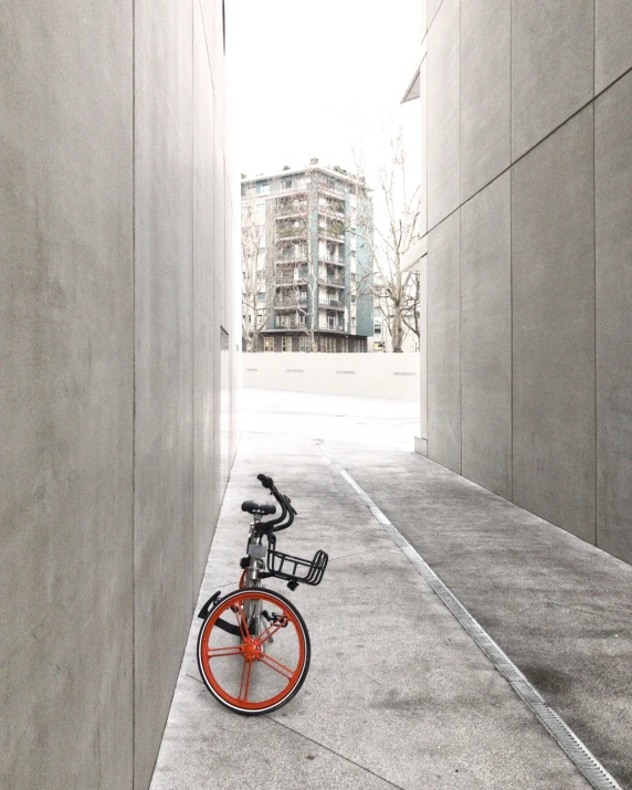 a bicycle in an alley with a building in the background