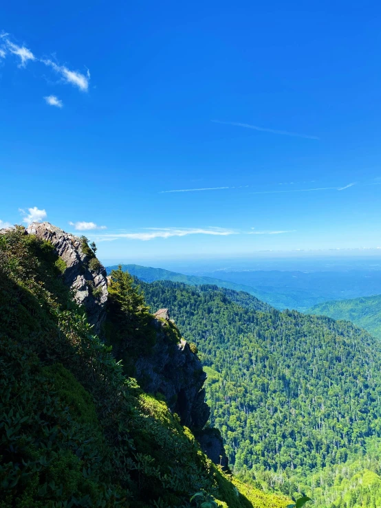 a scenic view from the edge of a cliff with blue skies