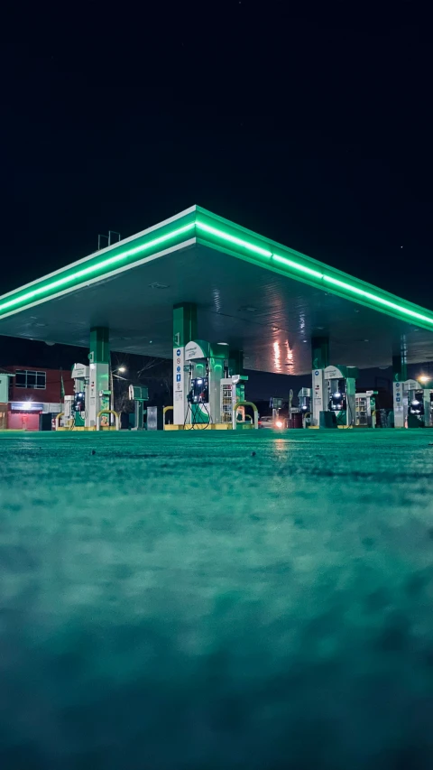 an empty gas station lit up at night with a large amount of lights on top