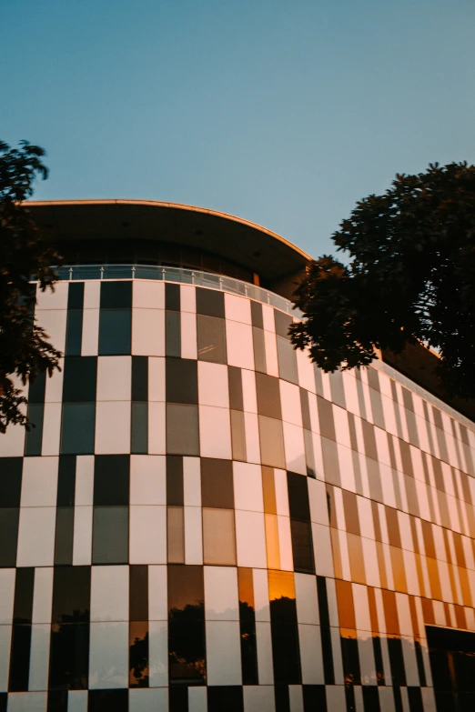 a multicolored building has trees outside it