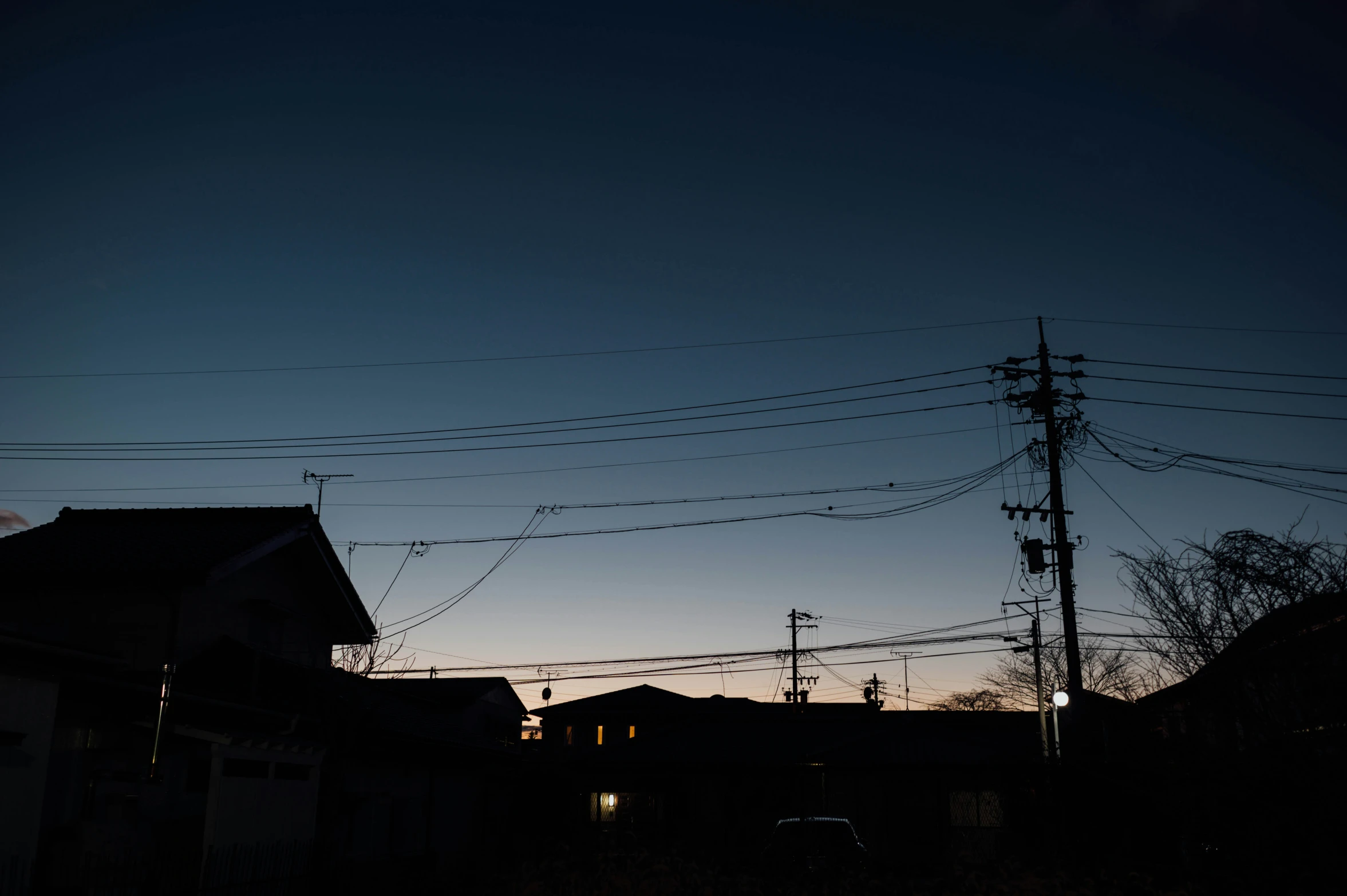 silhouette of an urban street at dusk with electrical wires overhead