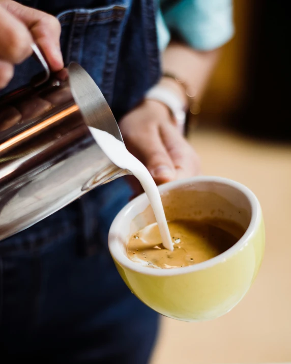 a person is pouring soing into a cup