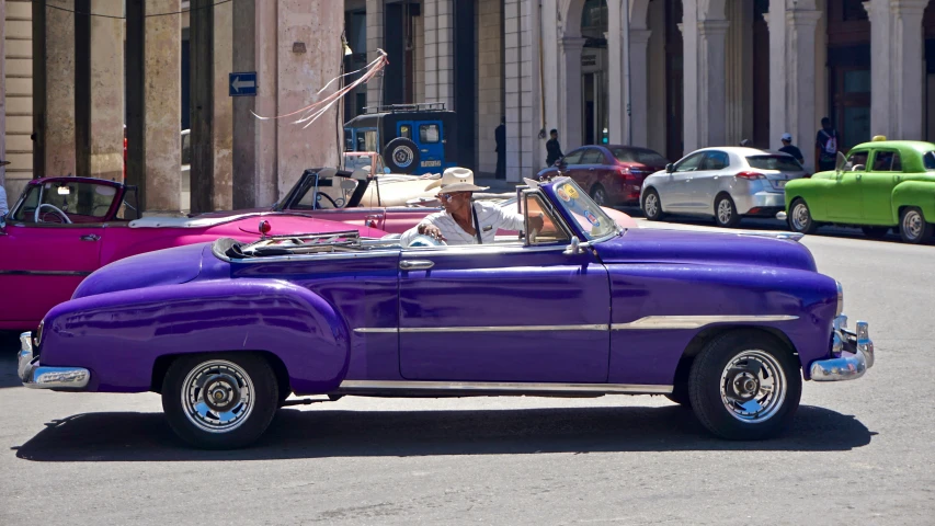 a purple convertible with two open seats parked on the street