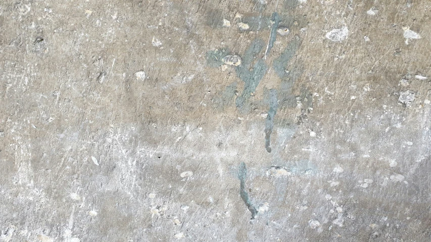 a large old dirty concrete surface with blue paint splattered on the cement