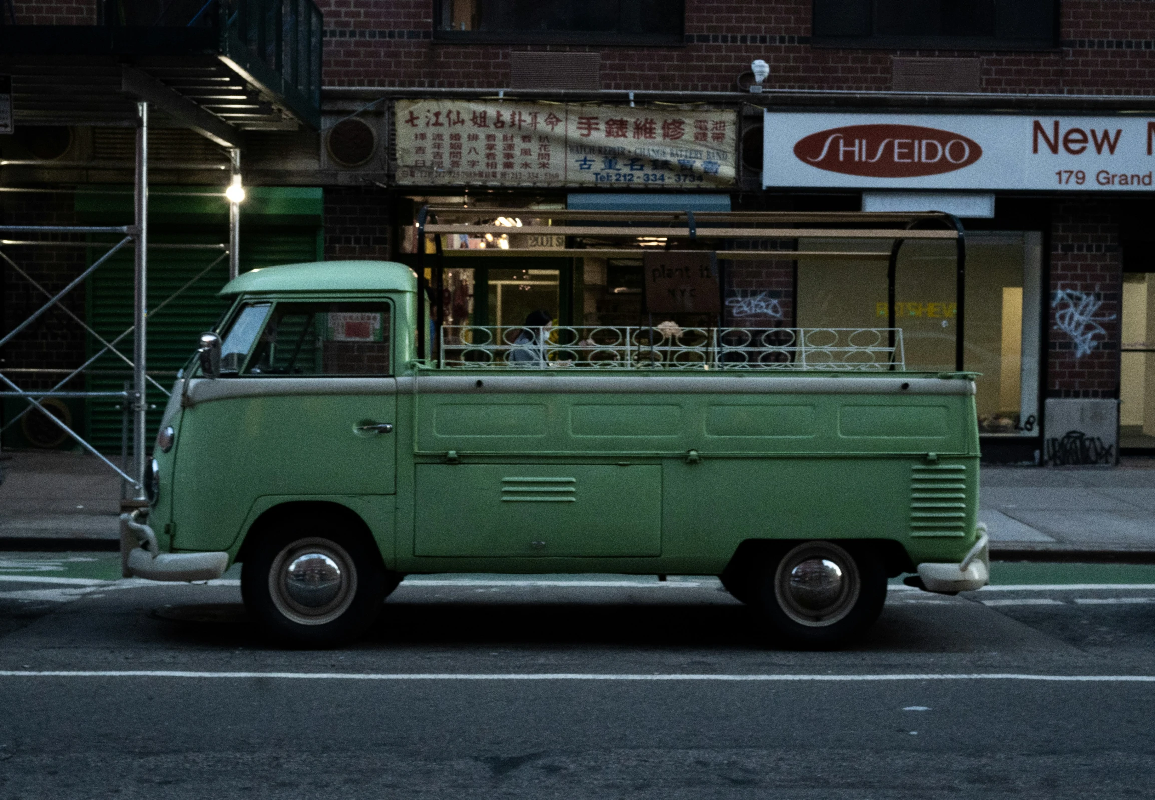 the green truck is parked on the side of the road