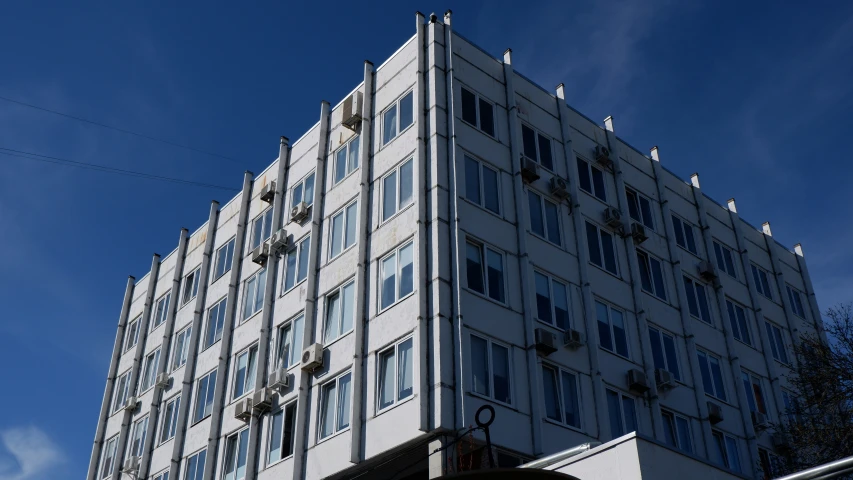 a large building with multiple windows against a blue sky