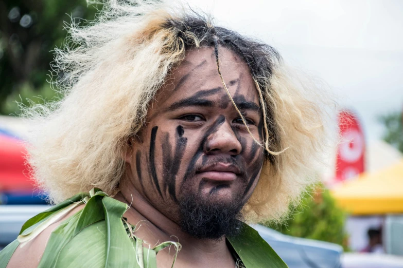 a man with elaborate painted face and head piece