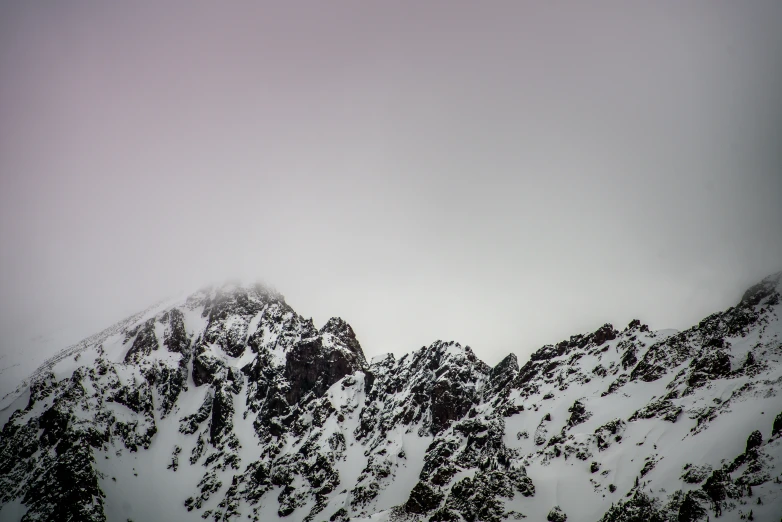 the mountains covered with snow under a very gray sky