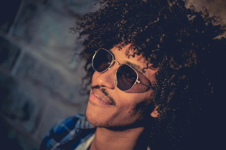 a man with curly hair wearing sunglasses