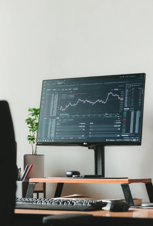 a computer monitor with a graphic screen on it sitting on a wooden desk