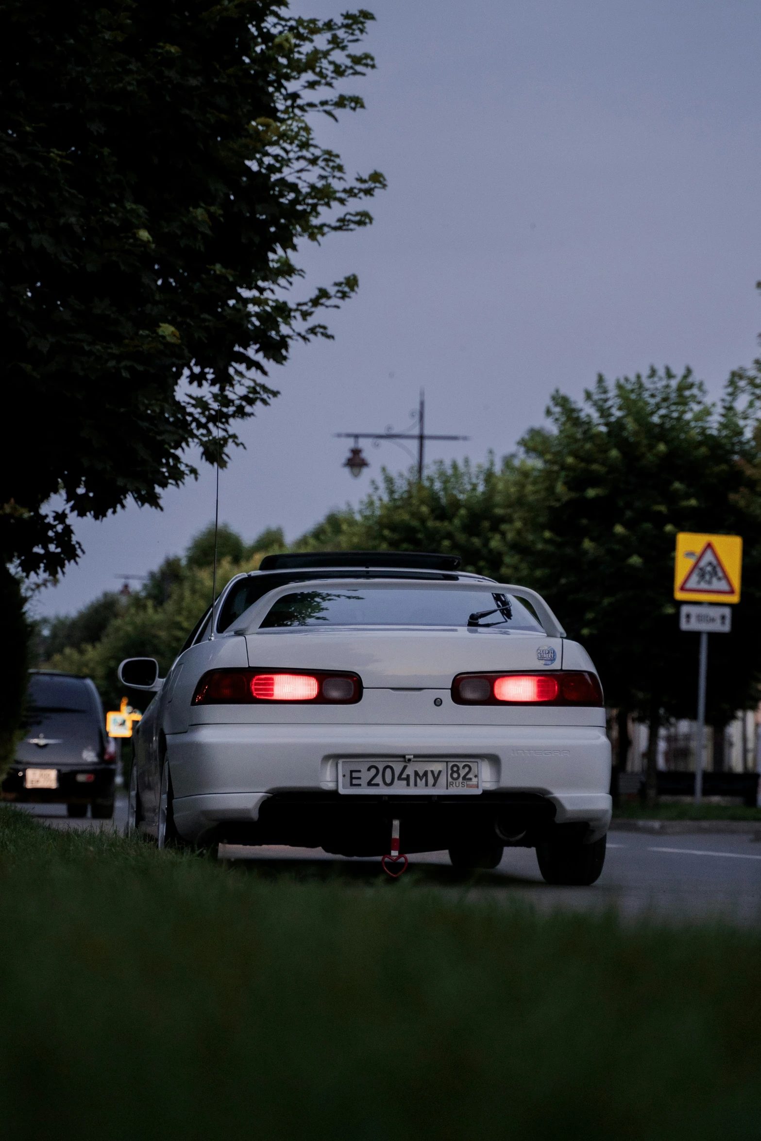 a car driving down the road next to trees