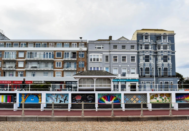 an ocean side city by the beach with people walking