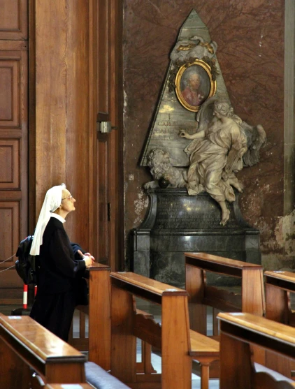 woman in church with statue, clock and door to other room