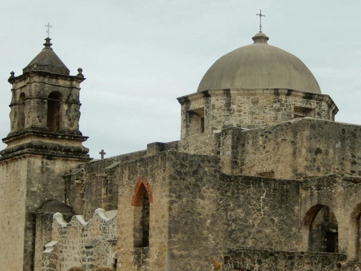 an old, gray building with two large domes