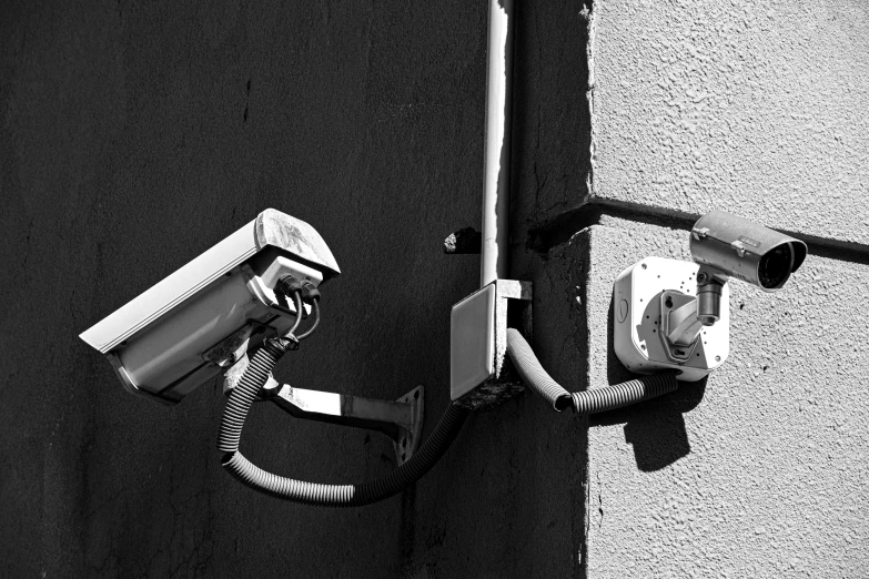 black and white po of security cameras on a wall