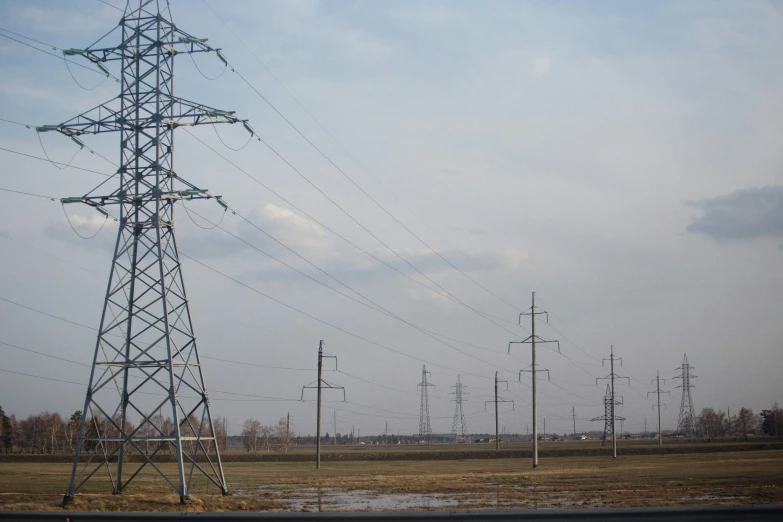 tall power lines stretching over a barren rural field