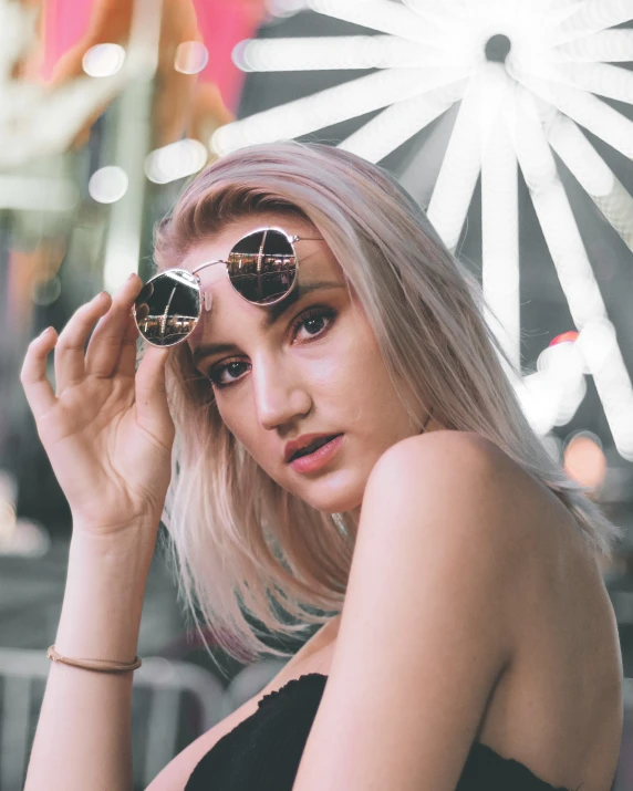 a woman with her sunglasses in front of a ferris wheel