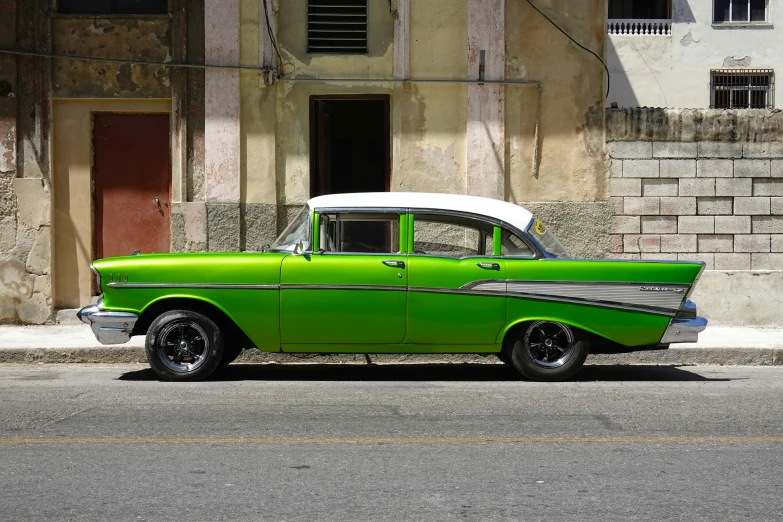 an old green car on the side of the road