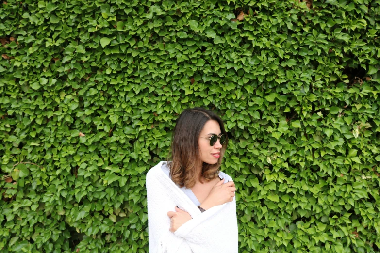 a woman in a bathrobe standing outside, looking into the camera