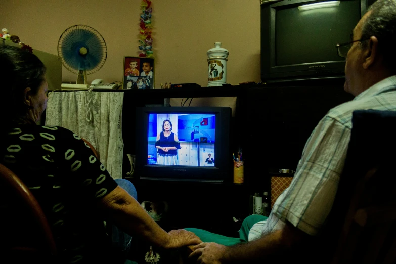 a couple are watching a television show on television