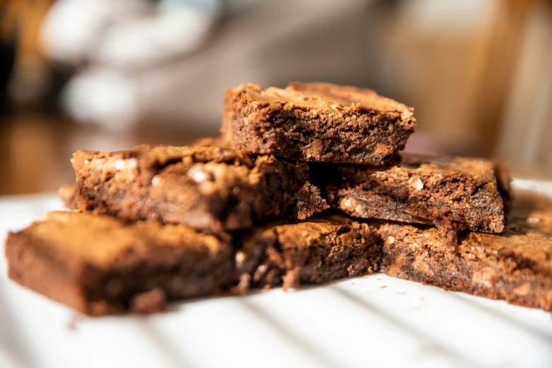 chocolate brownies stacked up on a table