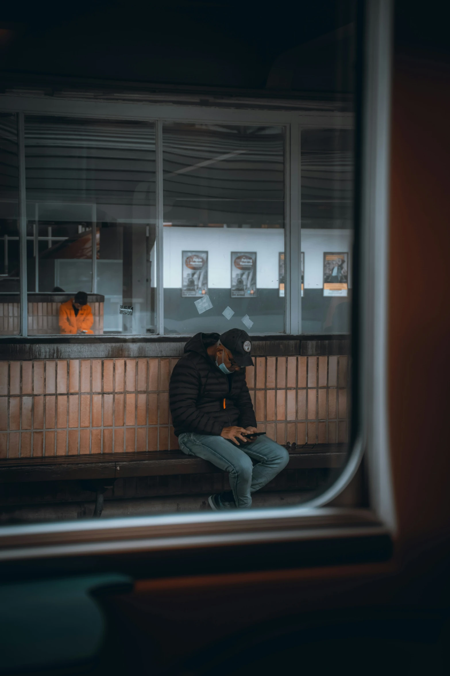 a man sits on a bench next to the window in the night