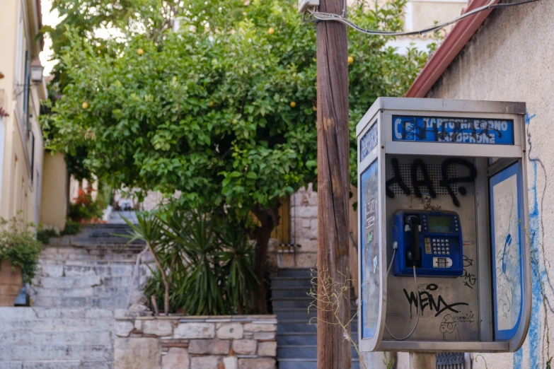 there is graffiti on the phone and graffiti on the street wall