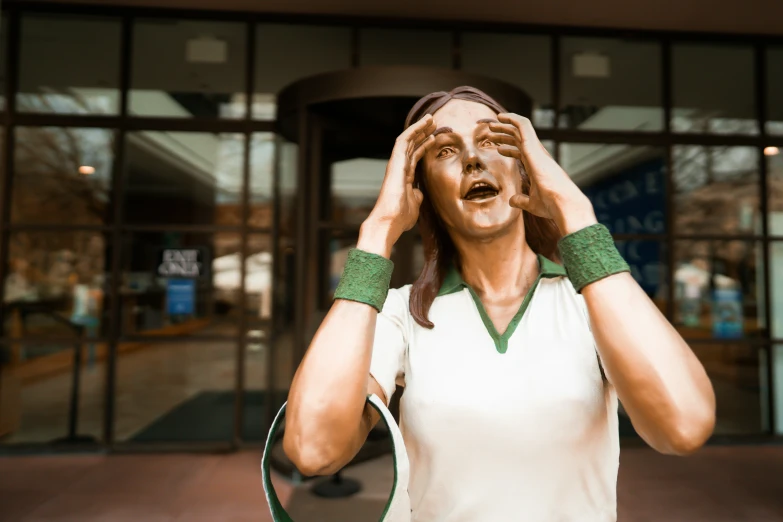 the woman is holding her head in front of a building