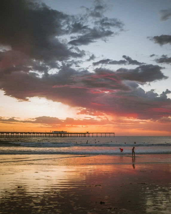 an image of people on the beach at dusk